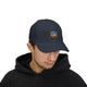 Un homme porte une casquette bleu marine avec le logo brodé Jesus est mon Superhéros.