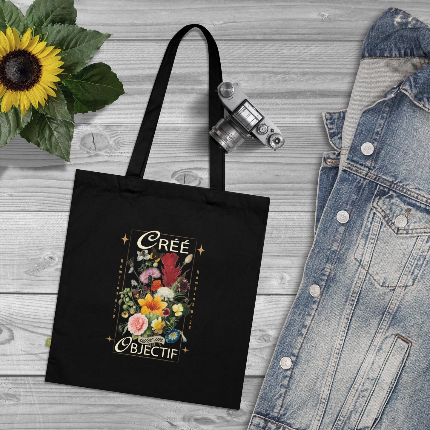 Tote bag noir en coton biologique orné d'un motif floral et de l'inscription Créé avec un objectif.