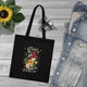 Tote bag noir en coton biologique orné d'un motif floral et de l'inscription Créé avec un objectif.