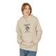 Une femme porte un sweat à capuche beige avec une illustration florale et un texte religieux.