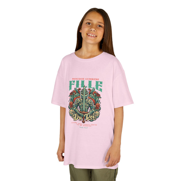 Une jeune fille porte un t-shirt rose clair avec une illustration de chevalier et un texte chrétien.