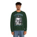 Un homme porte un sweatshirt vert foncé avec une illustration religieuse et le texte Il est ressuscité.