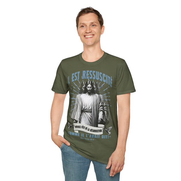 Un homme porte un t-shirt vert olive illustré de Jésus avec l'inscription Il est ressuscité.