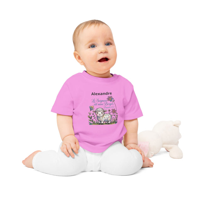 Bébé assis portant un t-shirt rose personnalisé avec un agneau et le texte Le Seigneur est mon Berger.