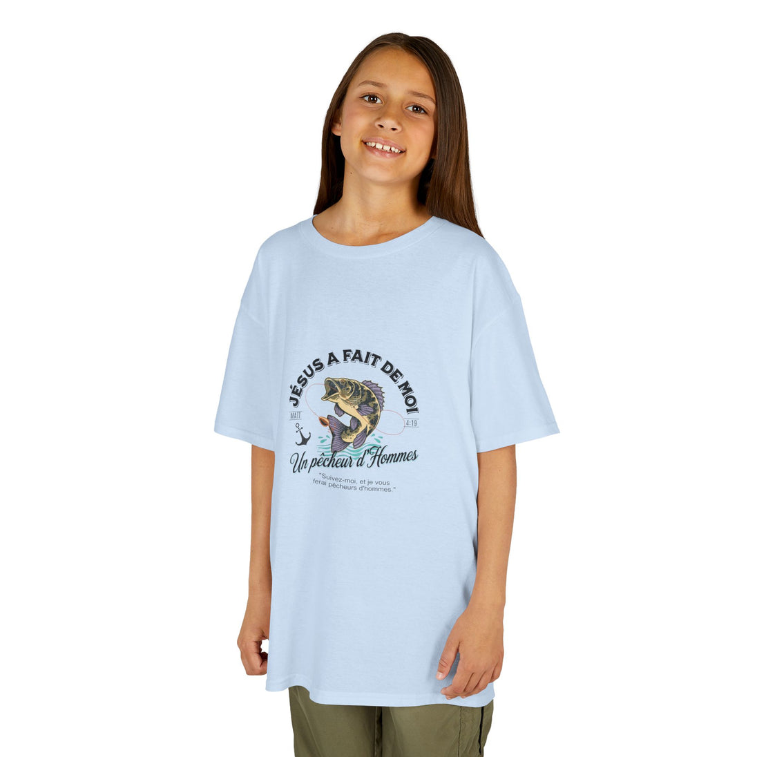 Une jeune fille porte un t-shirt bleu clair avec une illustration de poisson et un texte religieux.
