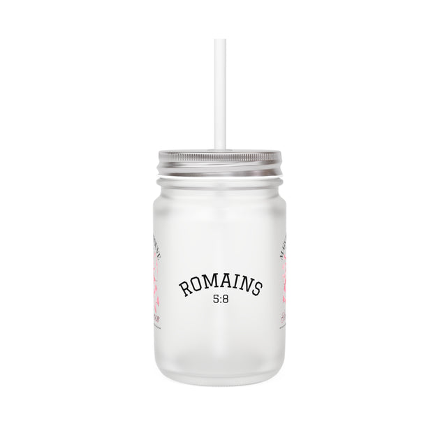 Un bocal Mason en verre dépoli avec couvercle, paille et l'inscription Romains 5:8.