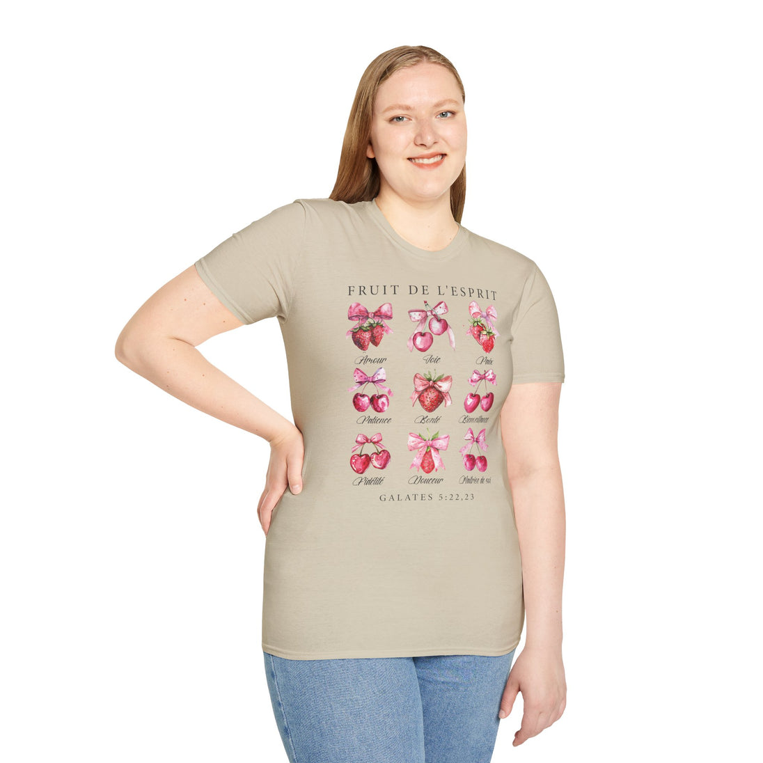 Une femme porte un t-shirt beige illustré de fruits et de textes sur le fruit de l'Esprit.