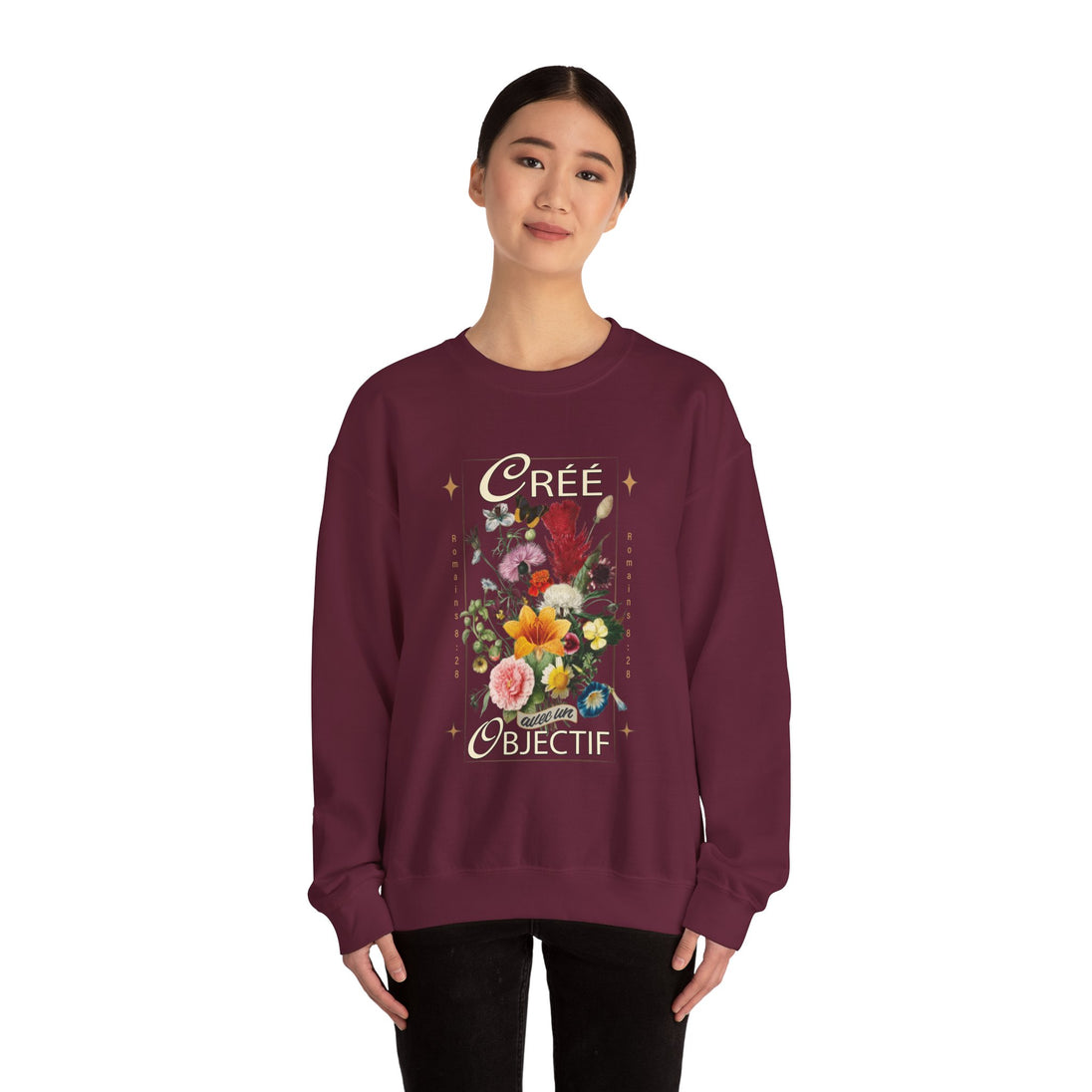 Une femme porte un sweatshirt bordeaux orné d'un motif floral vintage et du texte Créé avec un objectif.