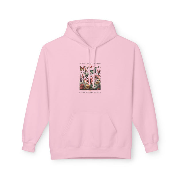 Sweat à capuche rose pâle avec une illustration florale et le texte Il fait toute chose belle.