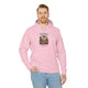 Un homme porte un sweat à capuche rose avec une illustration de désert et un verset biblique.
