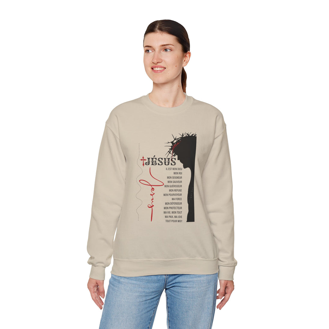Une femme porte un sweat-shirt beige orné d'une illustration religieuse et de textes en français.