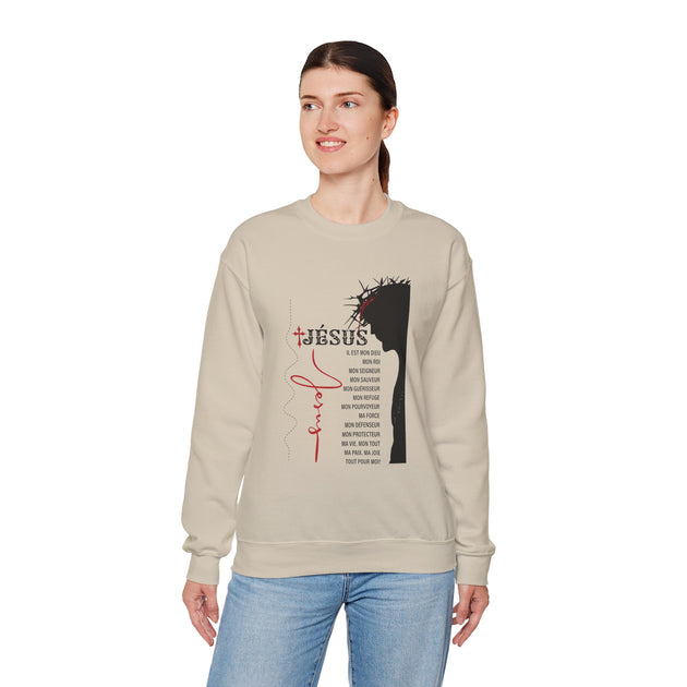 Une femme porte un sweat-shirt beige orné d'une illustration religieuse et de textes en français.