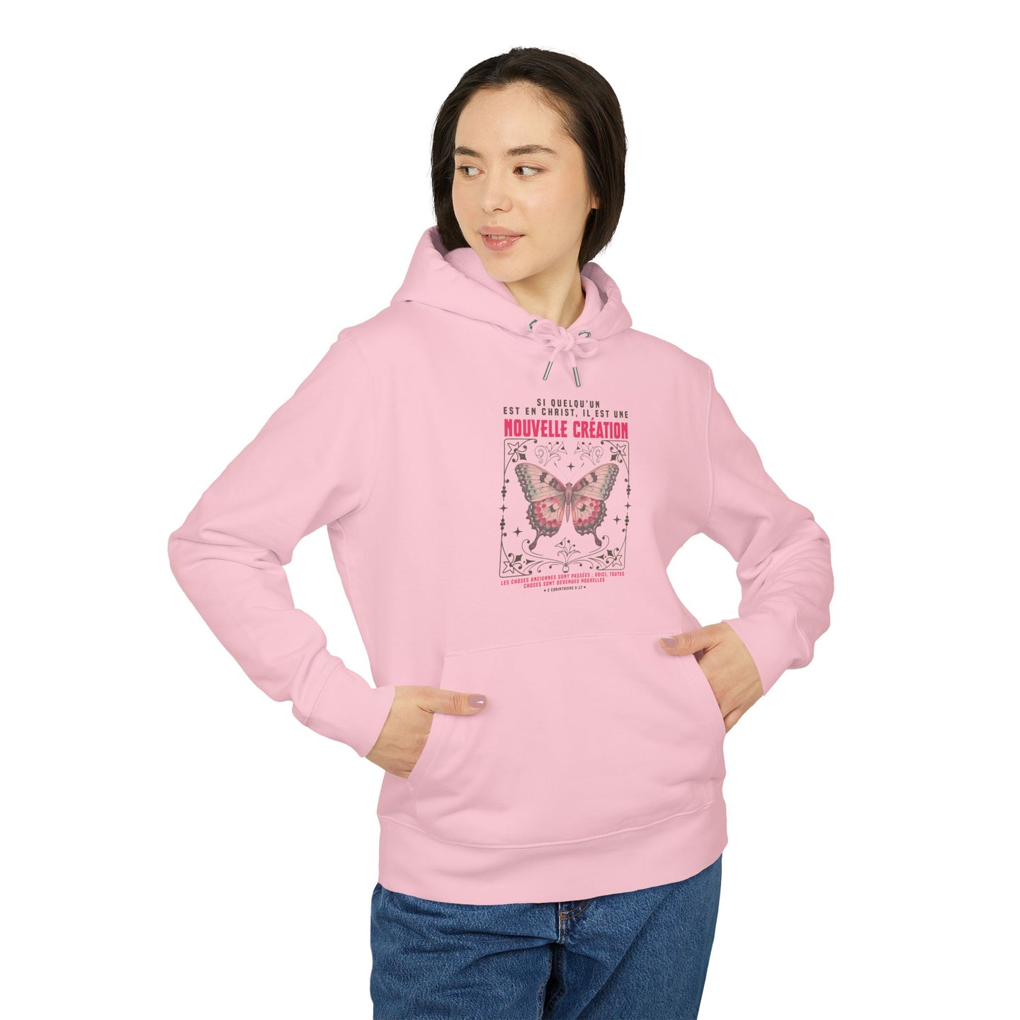 Une femme porte un sweat à capuche rose orné d'un motif de papillon et d'un verset biblique.