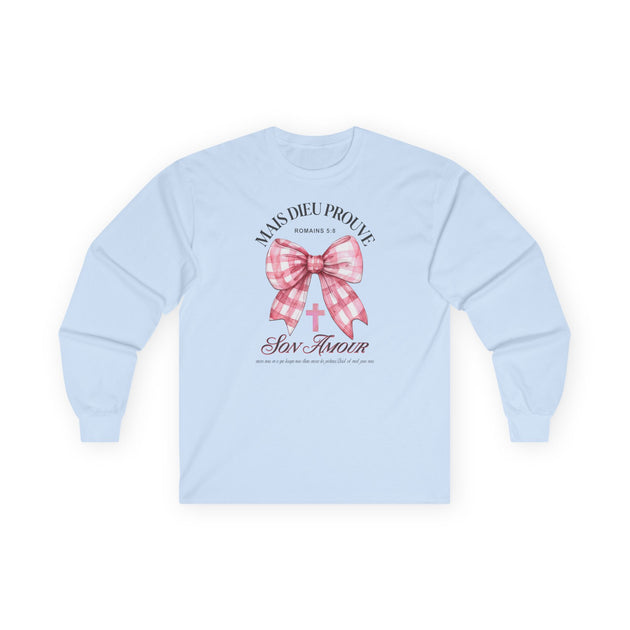 T-shirt bleu clair à manches longues avec un nœud vichy rose et une croix imprimés au centre.