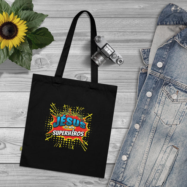 Tote bag noir en coton biologique avec le motif coloré Jésus est mon superhéros.