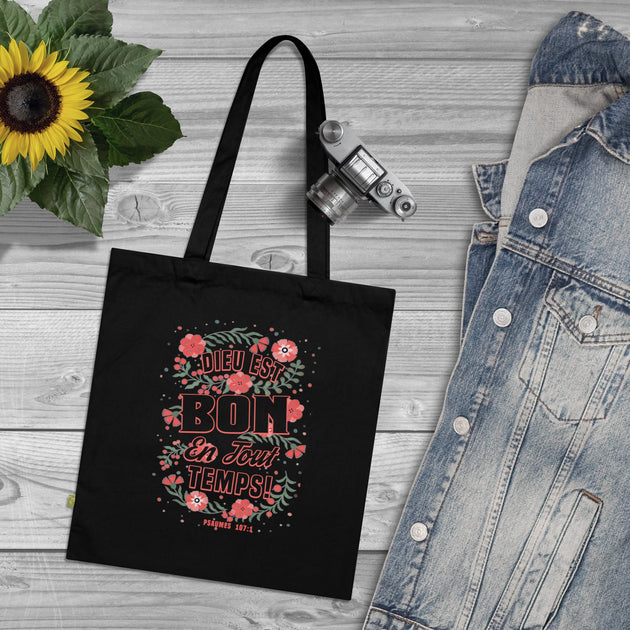 Tote bag noir en coton biologique orné d'un motif floral et de l'inscription Dieu est bon.