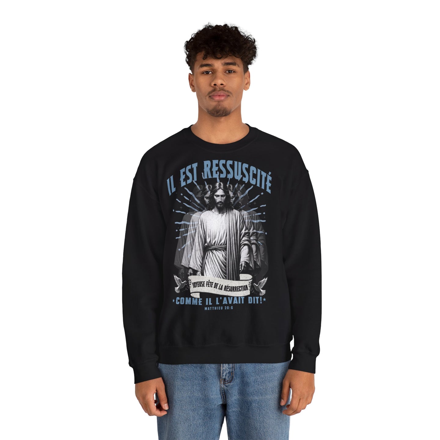 Un homme porte un sweatshirt noir avec une illustration religieuse et le texte Il est ressuscité.