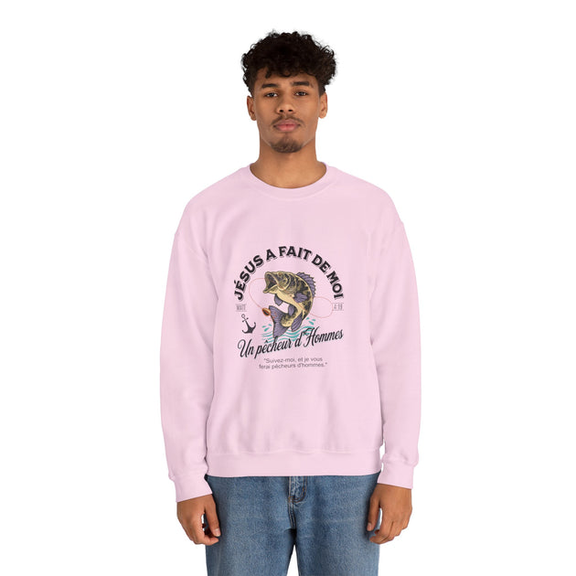 Un homme porte un sweatshirt rose clair avec une illustration de poisson et un texte religieux.