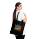 Une femme porte sur l'épaule un tote bag noir en coton avec l'inscription Jésus est mon Superhéros.
