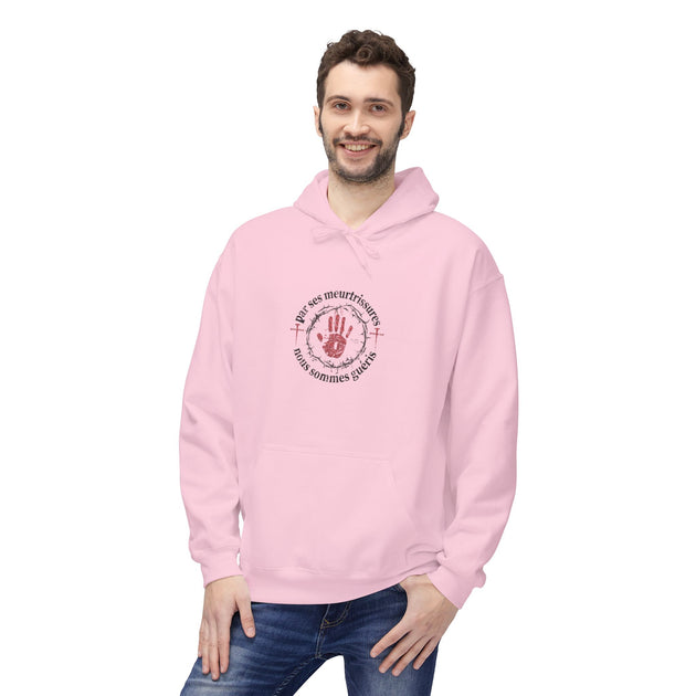 Un homme porte un sweat à capuche rose avec une impression religieuse sur la poitrine.