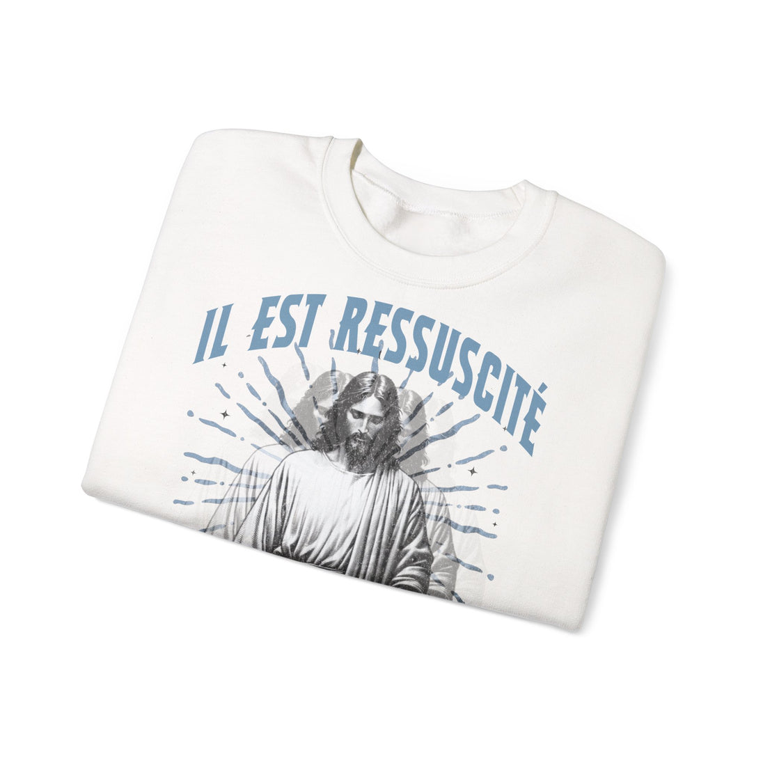 Sweatshirt blanc plié avec l'inscription Il est ressuscité et une illustration de Jésus.