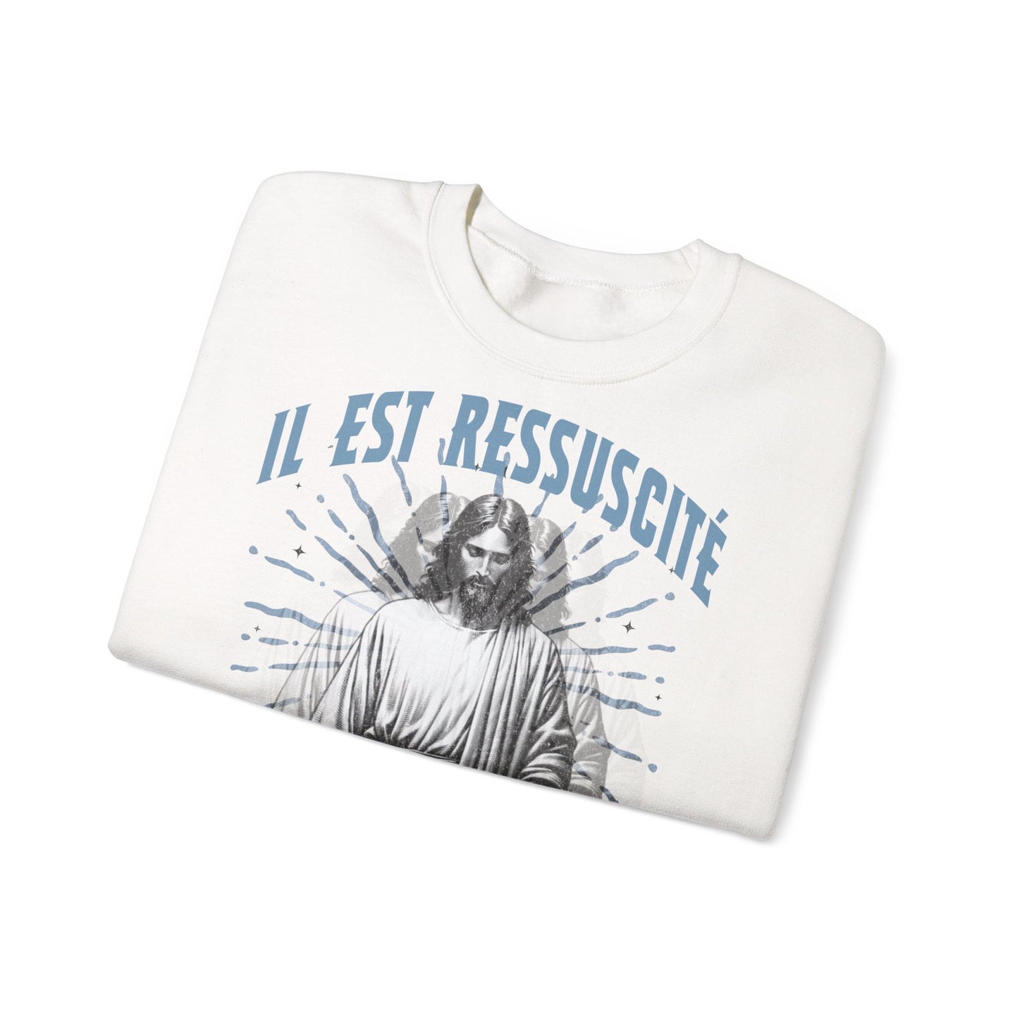 Sweatshirt blanc plié avec l'inscription Il est ressuscité et une illustration de Jésus.