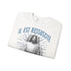 Sweatshirt blanc plié avec l'inscription Il est ressuscité et une illustration de Jésus.