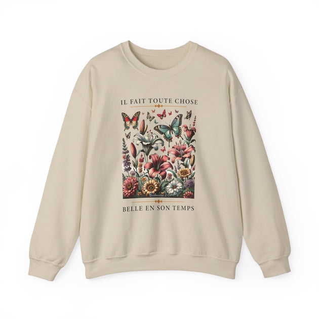 Sweat-shirt beige à col rond orné d'une illustration florale avec papillons et texte en français.