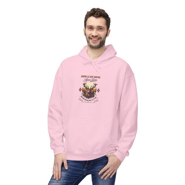 Un homme porte un sweat à capuche rose avec une illustration de cerf et un texte religieux.