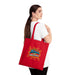 Une femme porte sur l'épaule un tote bag rouge en coton avec l'inscription Jésus est mon Superhéros.