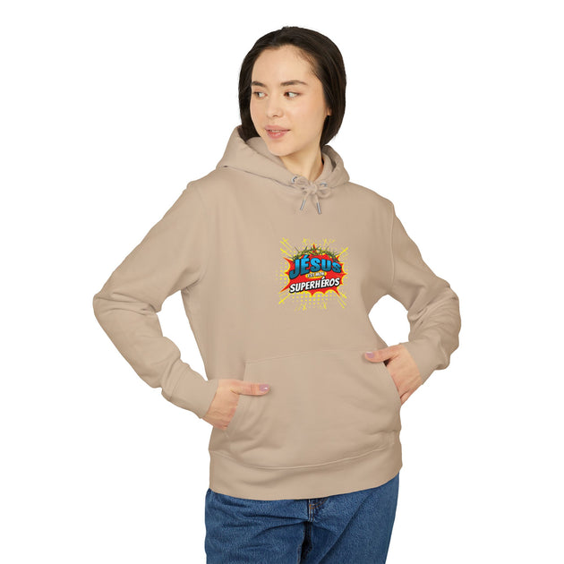 Une femme porte un sweat à capuche beige avec le motif Jésus est mon superhéros sur la poitrine.