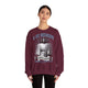 Une femme porte un sweatshirt bordeaux avec une illustration religieuse et le texte Il est ressuscité.