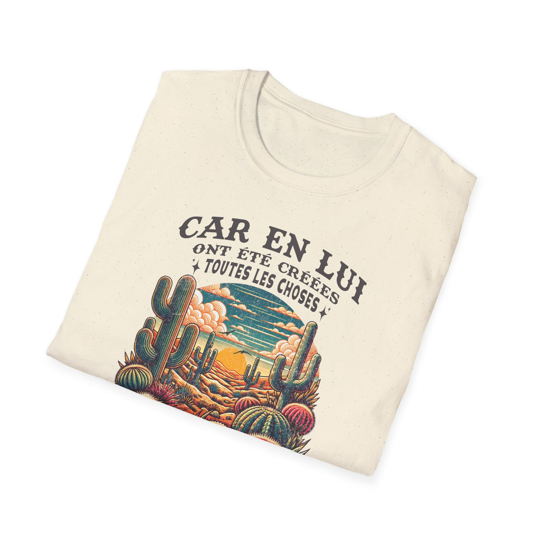 T-shirt beige plié avec une illustration de désert et le texte Car en lui ont été créées toutes les choses.