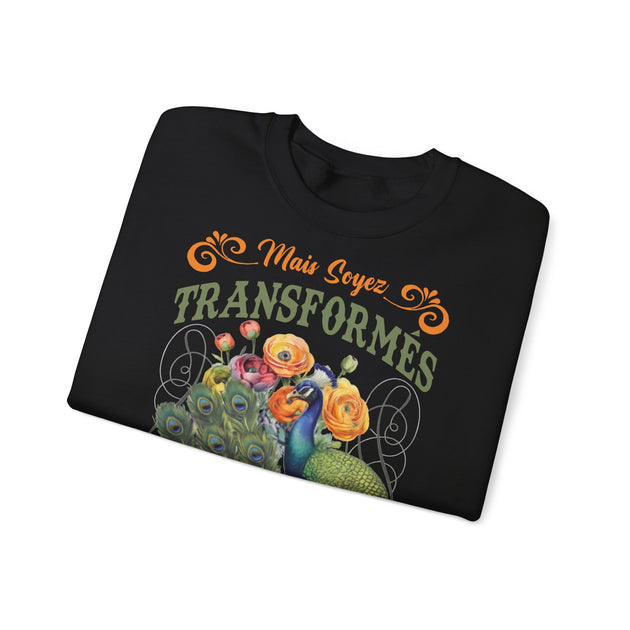 Sweat-shirt noir plié avec une illustration de paon, de fleurs et le texte Mais soyez transformés.