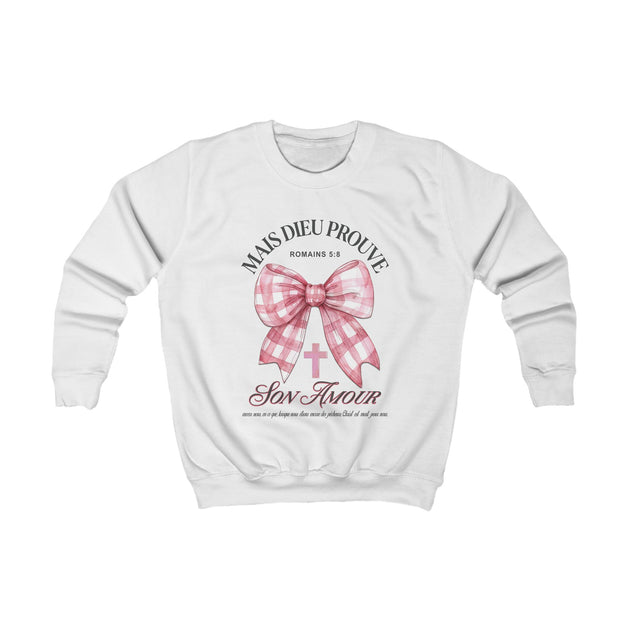 Sweat-shirt blanc pour enfant avec un nœud vichy rose, une croix et le texte Mais Dieu Prouve.