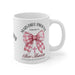 Mug blanc en céramique orné d'un nœud rose à carreaux et du verset biblique Romains 5:8.