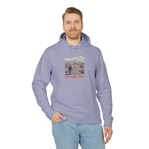 Un homme porte un sweat à capuche bleu clair avec une illustration de cowboy et un texte religieux.