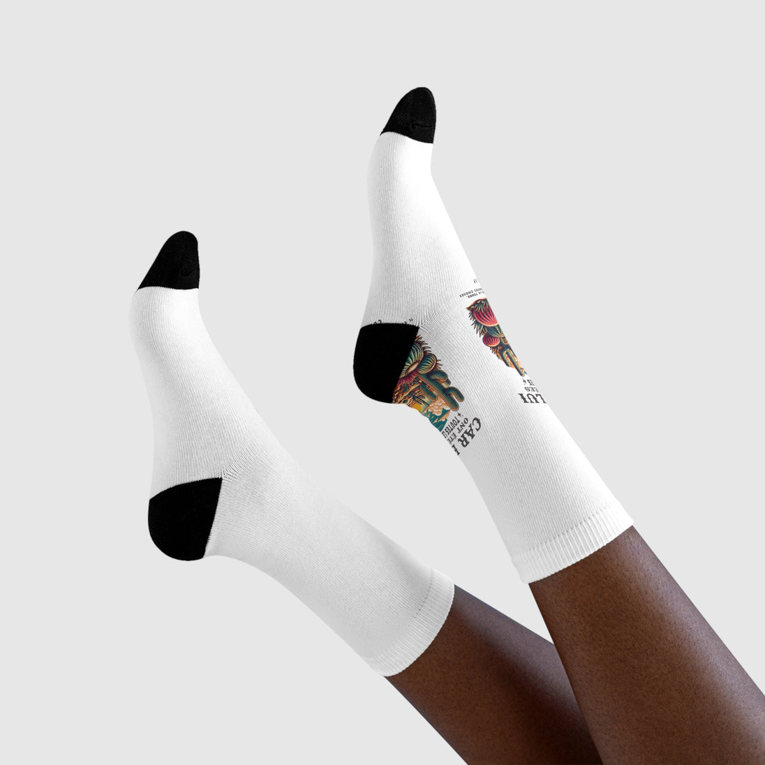 Paire de chaussettes blanches avec talons et pointes noirs, ornées d'un motif floral coloré.