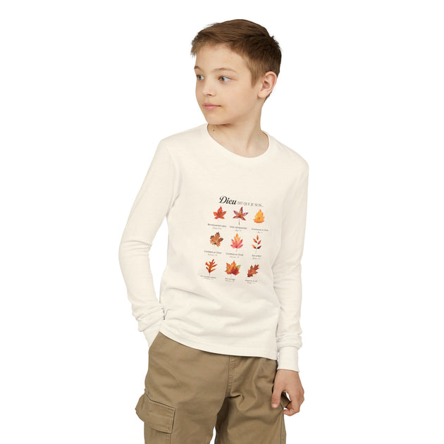 Un enfant porte un t-shirt à manches longues blanc orné d'un motif de feuilles et de texte.
