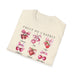 T-shirt beige plié orné d'illustrations aquarelles de fruits et de mots inspirants.