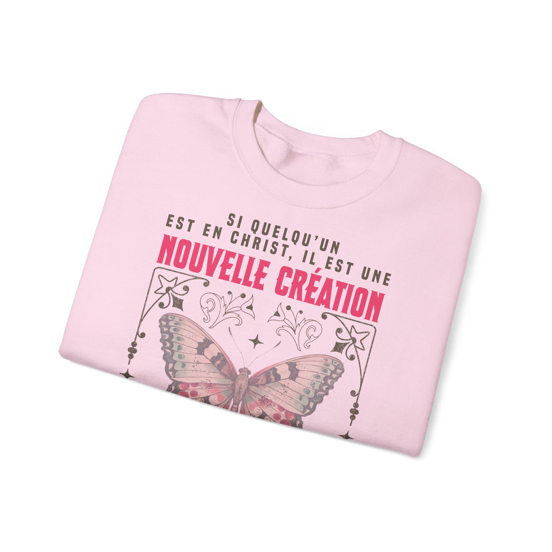 Sweat-shirt rose plié avec un papillon et le texte Si quelqu'un est en Christ, il est une création.