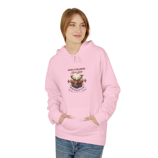 Une femme porte un sweat à capuche rose avec une illustration de cerf et un verset biblique.