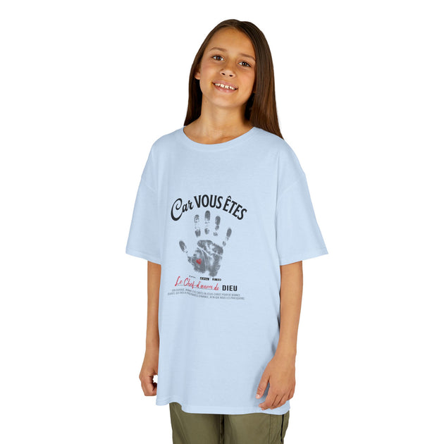 Une jeune fille porte un t-shirt bleu clair avec une empreinte de main et un message religieux.