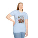 Une femme porte un t-shirt bleu clair orné d'un motif floral, de papillons et d'un texte religieux.