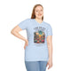 Une femme porte un t-shirt bleu clair avec une illustration de désert et un verset biblique.