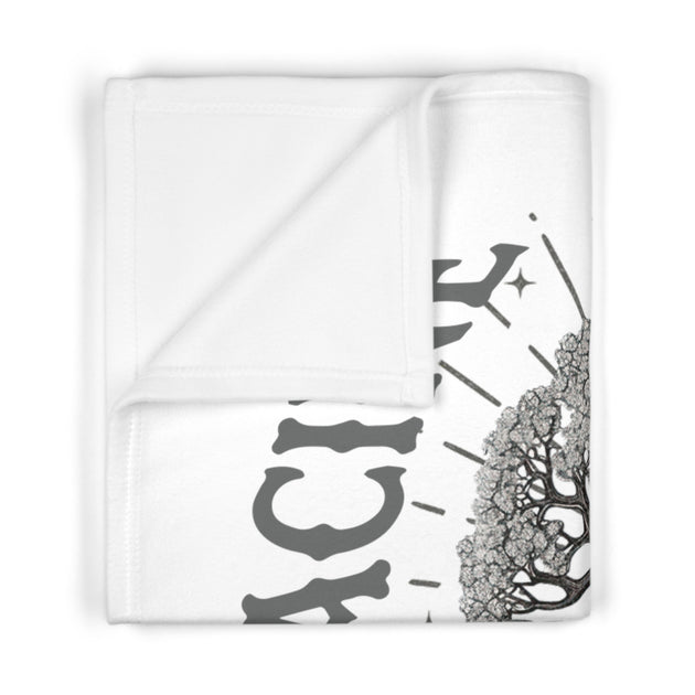 Couverture blanche pour bébé ornée d'un motif d'arbre et de texte gris.