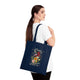 Une femme porte sur l'épaule un sac fourre-tout bleu marine orné d'un motif floral et du texte Créé.