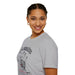 Une femme porte un t-shirt gris avec une empreinte de main et le texte Car vous êtes.