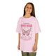 Une jeune fille porte un t-shirt rose orné d'un papillon et d'un verset biblique en français.
