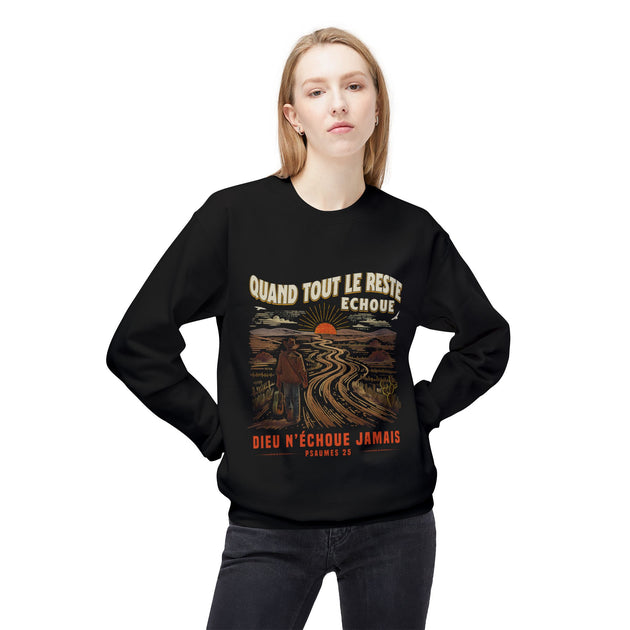 Une femme porte un sweat-shirt noir avec une illustration de paysage et un message chrétien.
